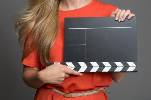 Eine Frau hält eine unbeschriftete Filmklappe