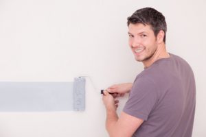 Ein Mann streicht seine Wand im Stil seines Sternzeichens