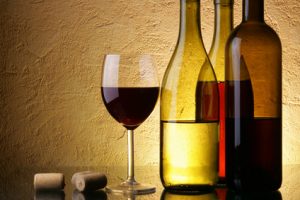 Drei Weinflaschen und ein Weinglas