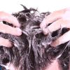 Mann reibt sich mit Shampoo die Haare ein