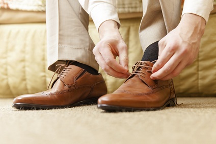 Mann schnürt seine Schuhe