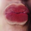 Frau küsst Glasscheibe