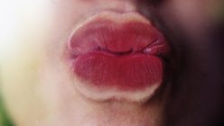 Frau küsst Glasscheibe